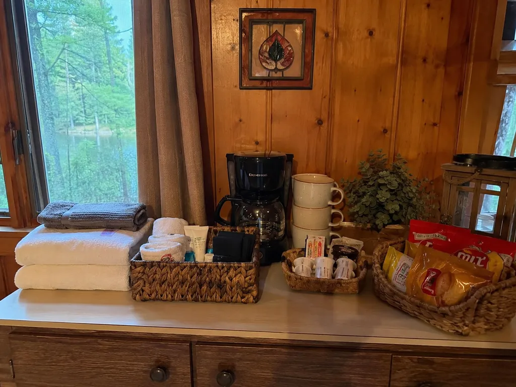 A wooden counter with baskets of snacks, towels, and a coffee maker.